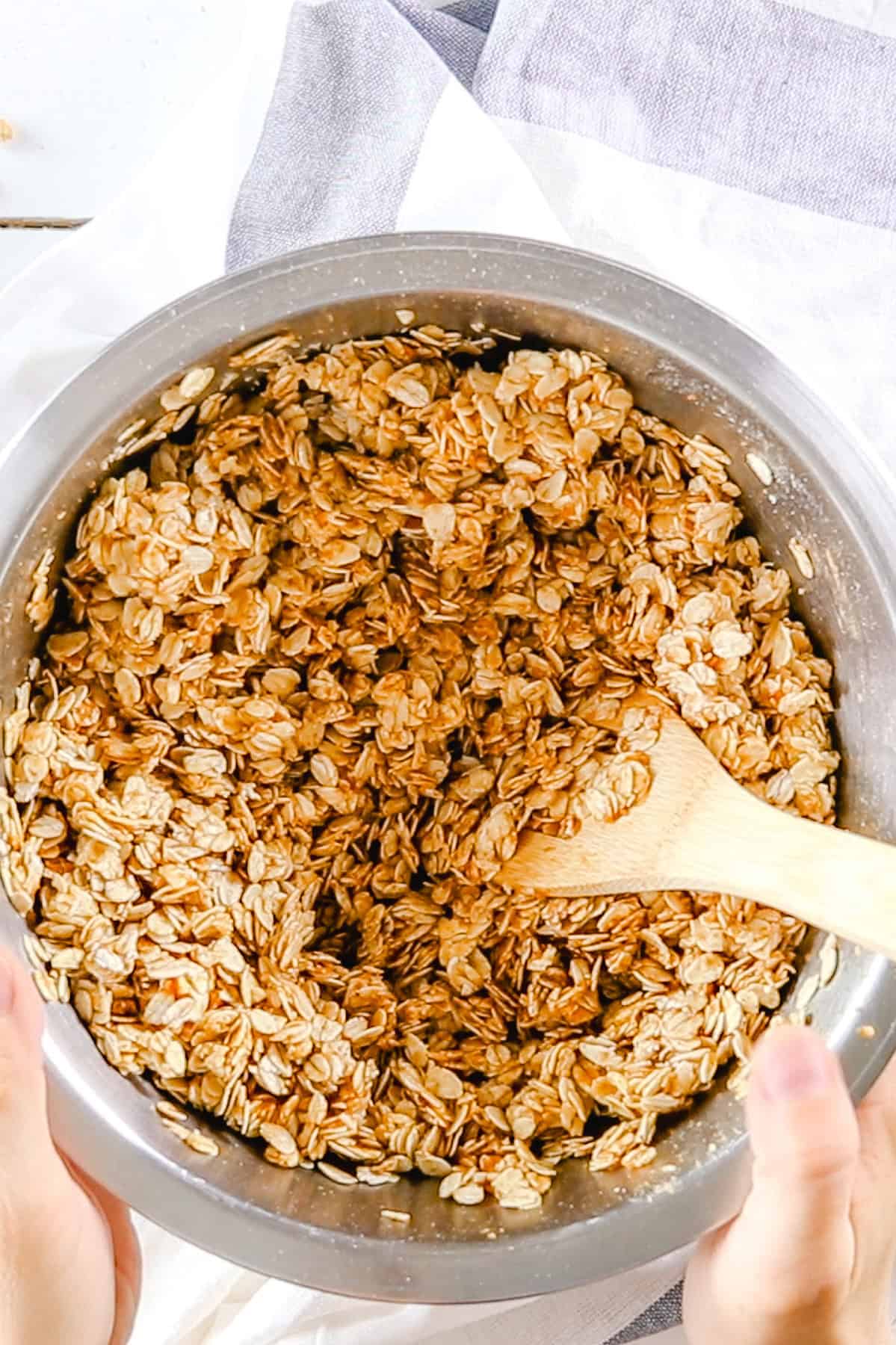 Stirring the ingredients for pumpkin granola in a big mixing bowl.