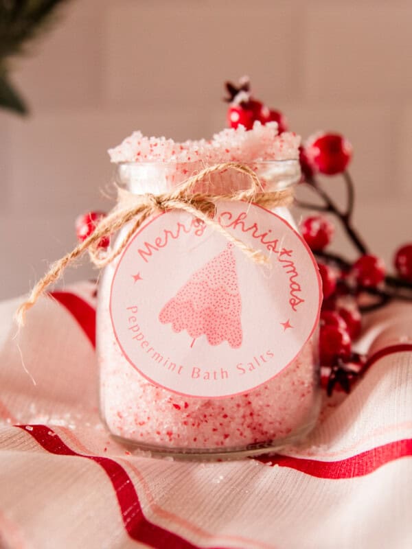 A jar of peppermint bath salts with a homemade label and red berries.