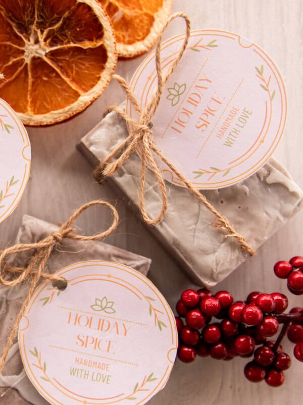 Holiday spice soap bars with holiday gift tags, red berries, and dried oranges.