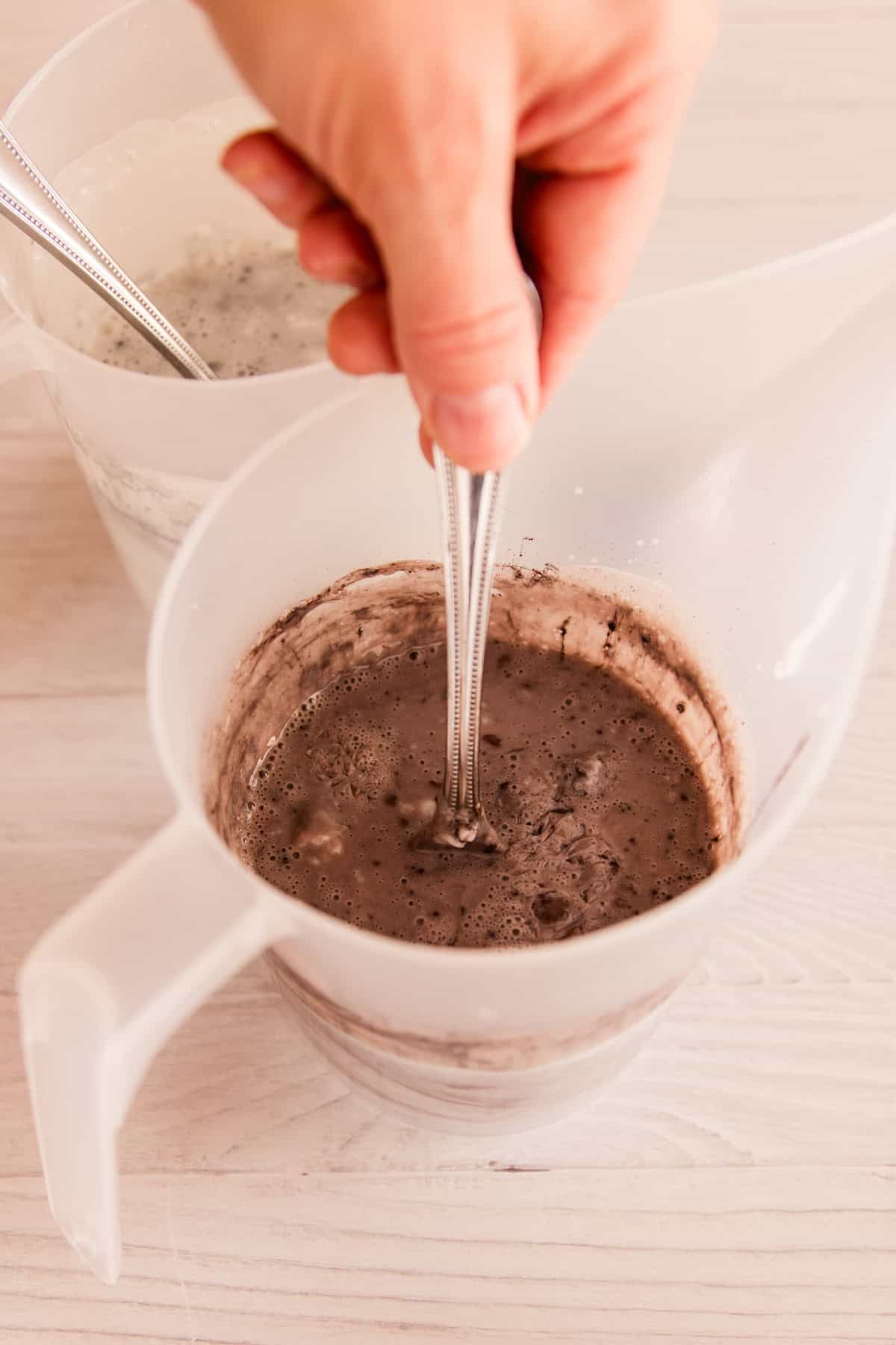 Stirring a bowl of melted soap base with mica powder.