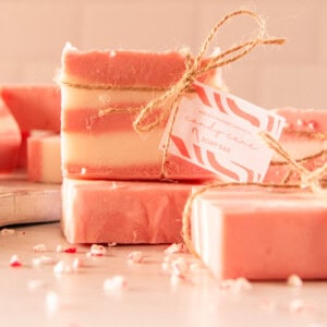 A stack of candy cane soap bars tied with hemp twine and a homemade gift tag.