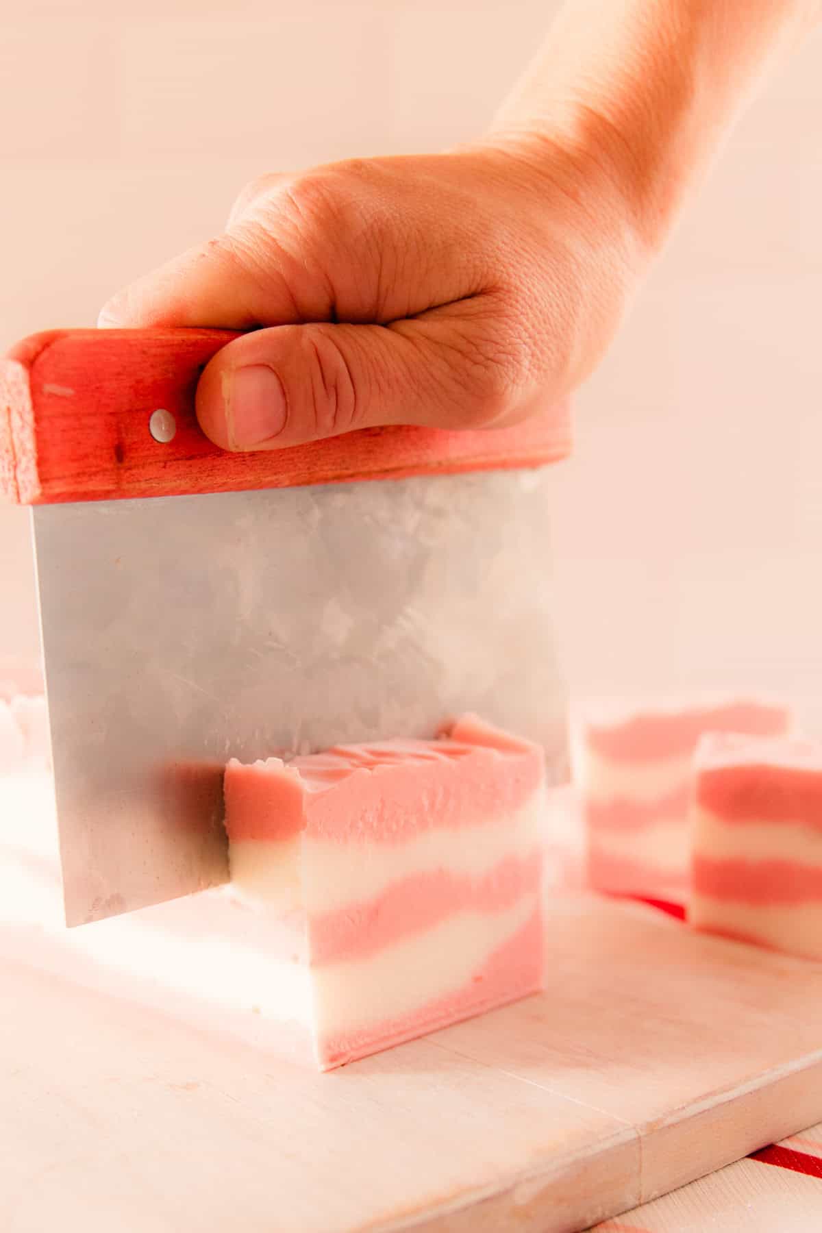 Cutting candy cand soap with a soap cutter.
