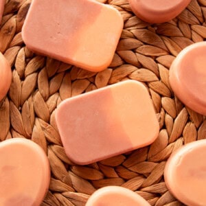 Bars of orange creamsicle soap spread on a wicker background.