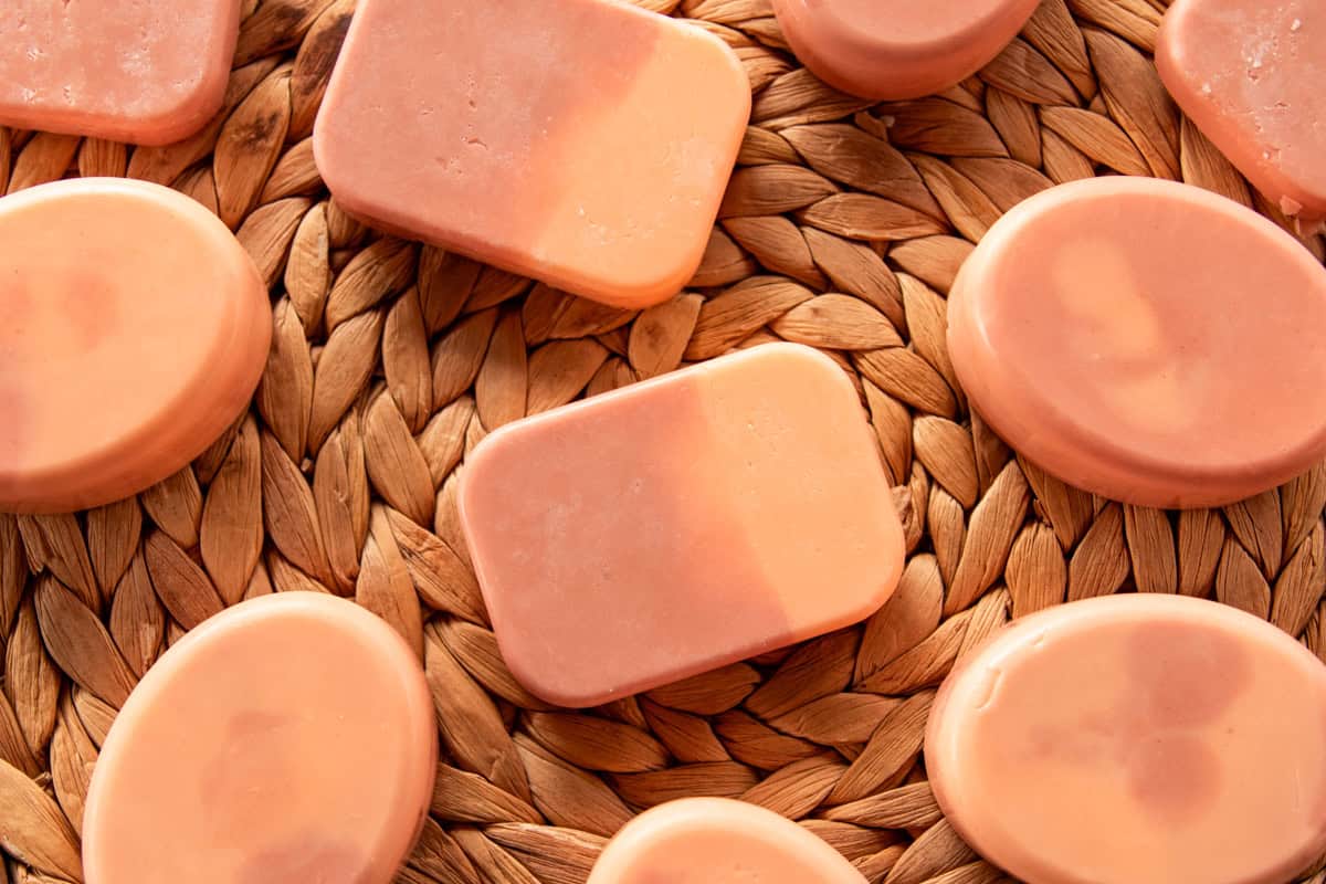 Bars of orange creamsicle soap spread on a wicker background.