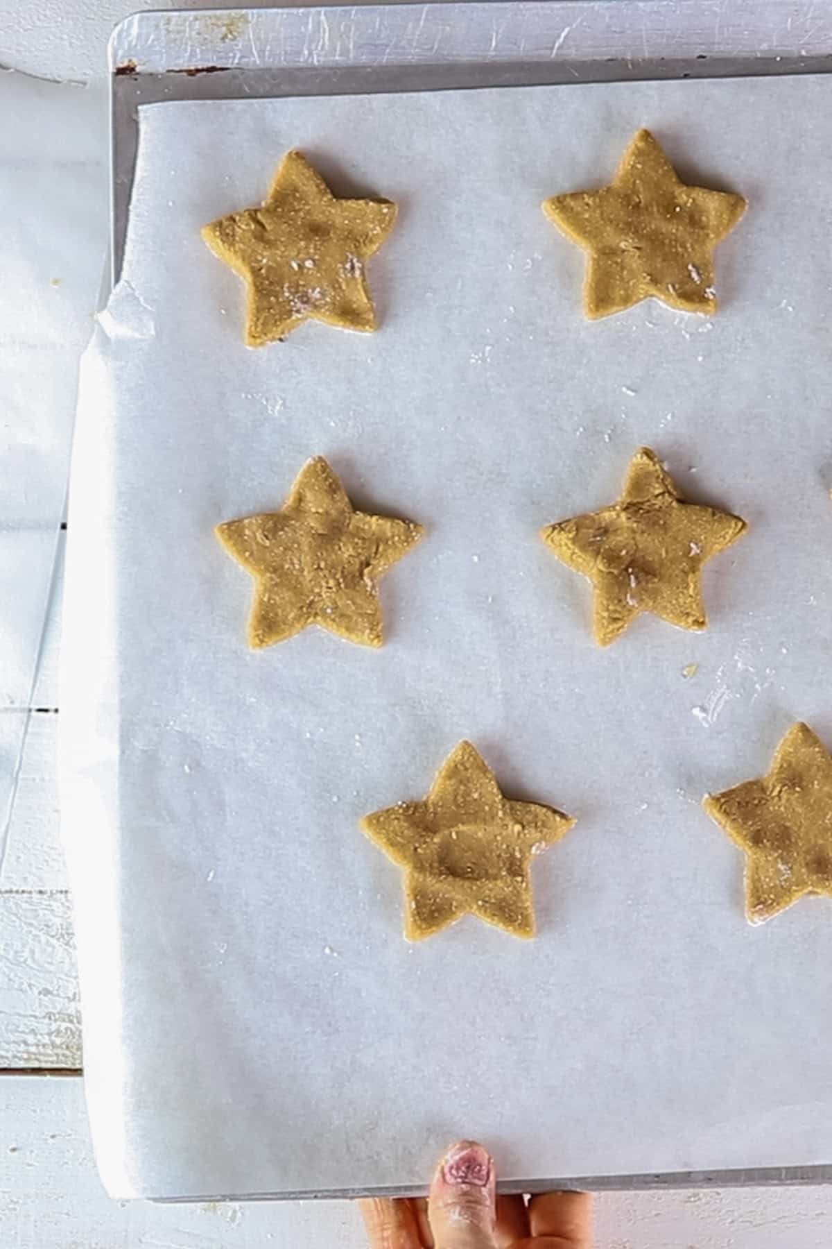 Star-shaped sugar cookies on a baking sheet before baking.