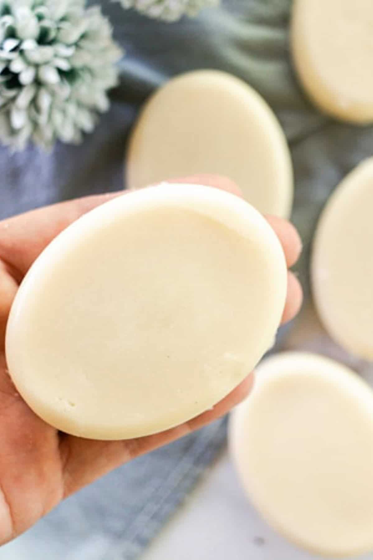 Holding a coconut milk soap bar over a marble vanity.
