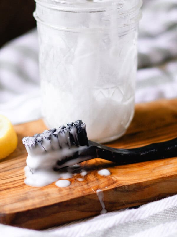 A jar of grout cleaner with a scrub brush.