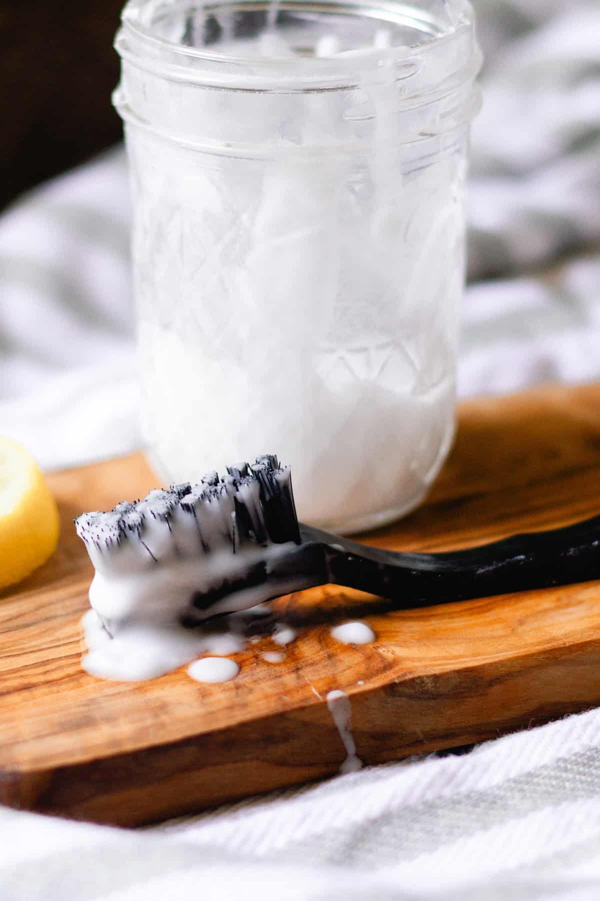 A jar of grout cleaner with a scrub brush.
