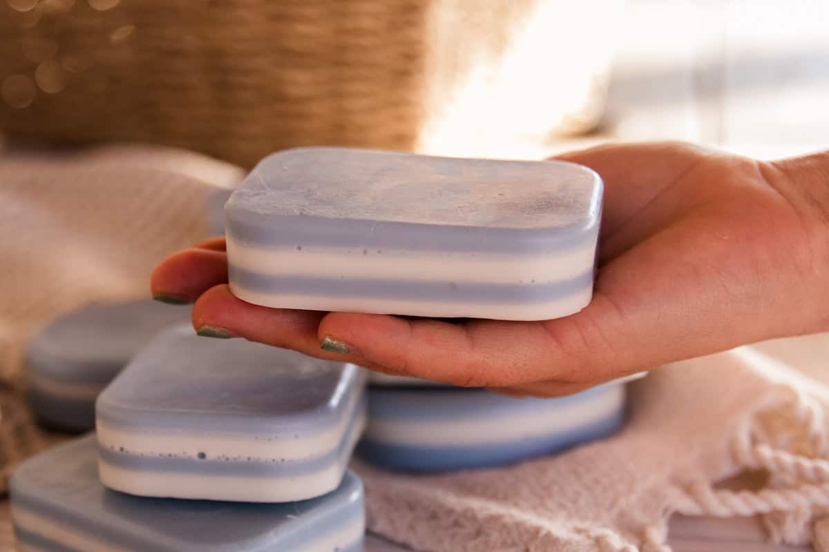 Holding a bar of layered peppermint soap.