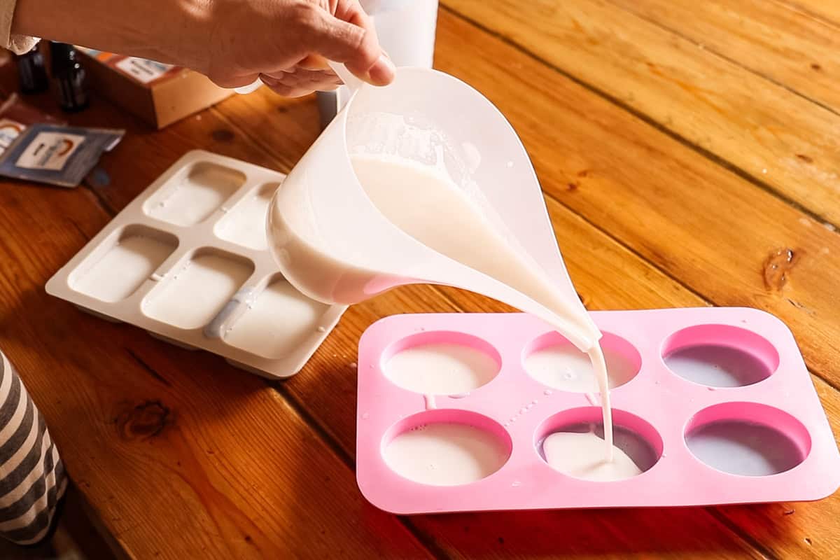 Pouring melted soap base into silicone soap molds.