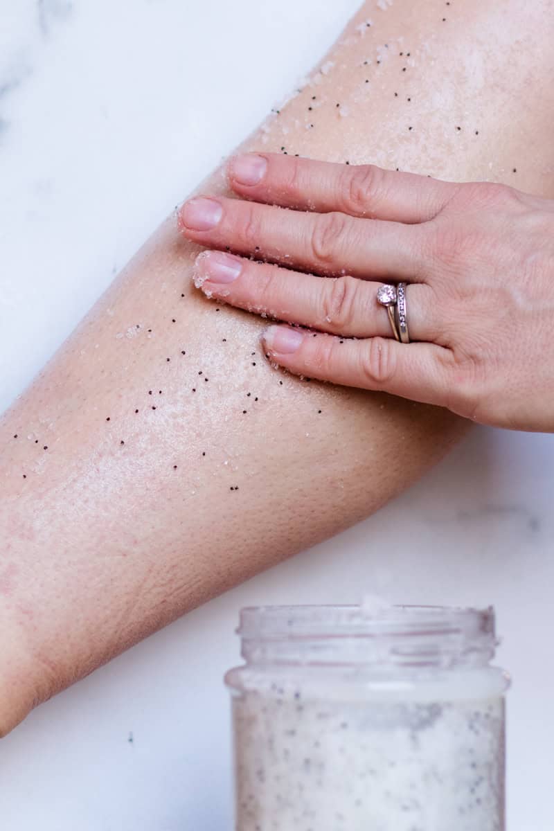 Spreading dead sea salt scrub on an arm.