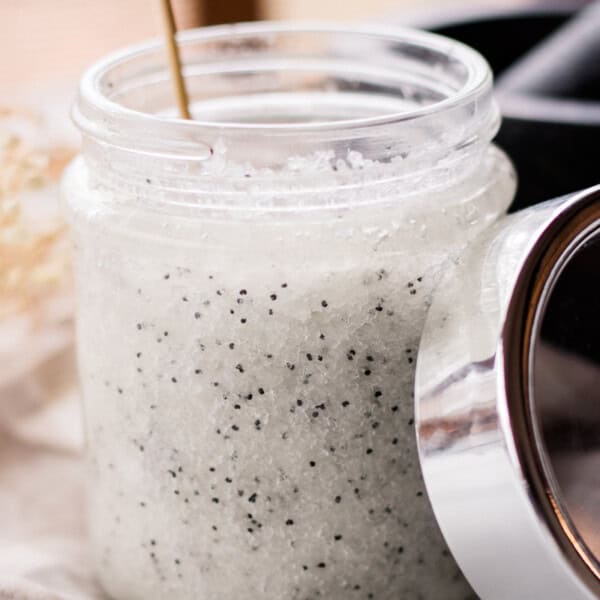 A jar of dead sea salt scrub with a spoon sticking out of it.