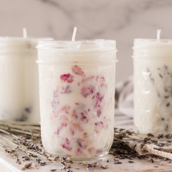 Three mason jar candles with dried flowers.