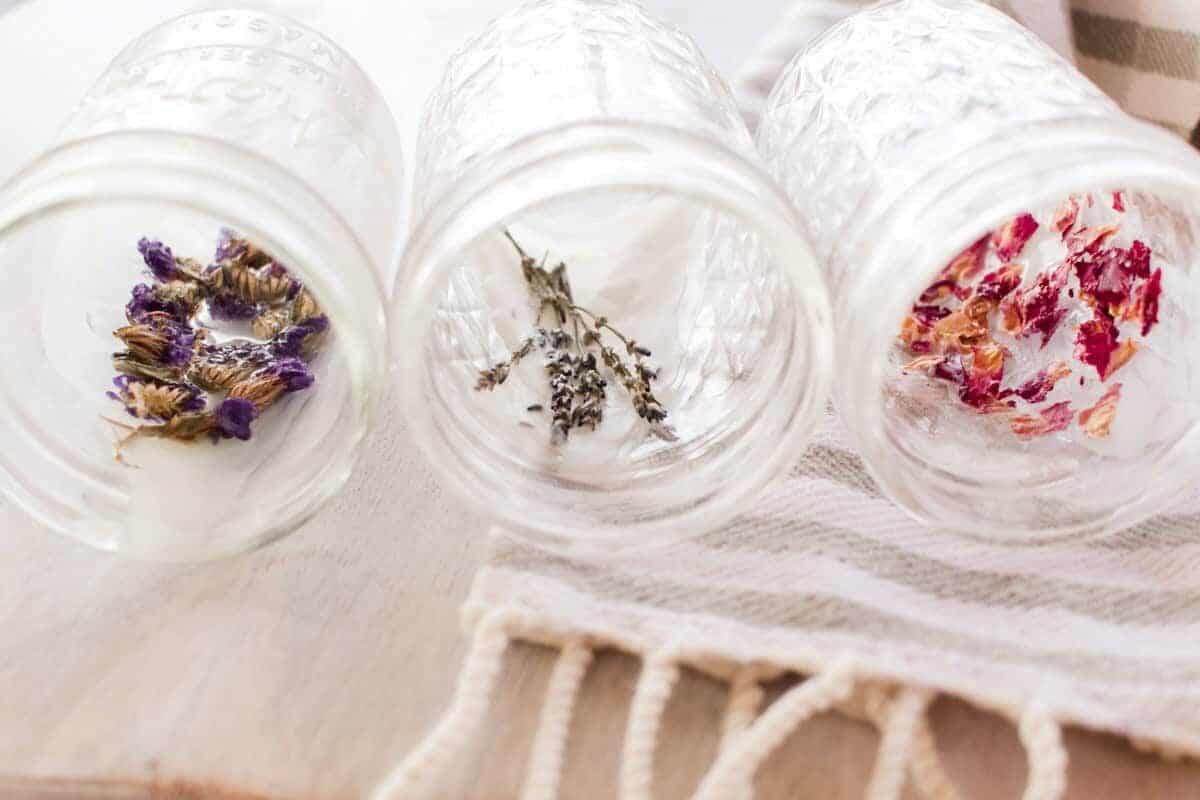 Empty jars with dried flowers laid against the wall of the jar.