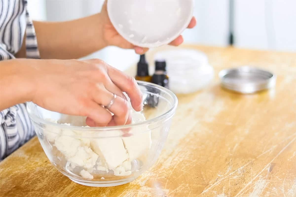 Adding the chunks of shea butter to a glass bowl.