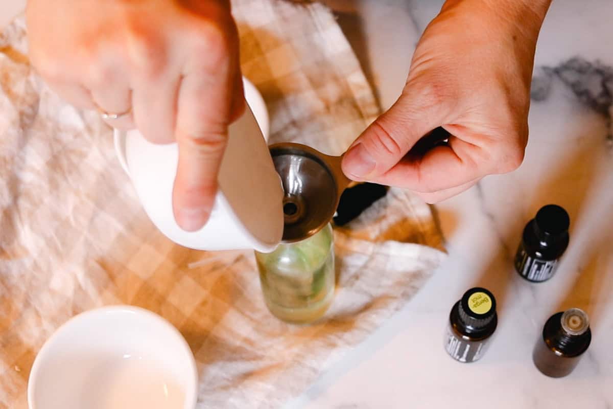 Pouring liquid into a glass spray bottle.