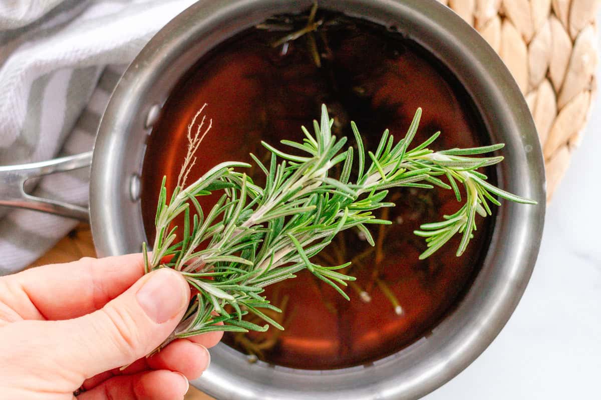 Adding in the rosemary to the boiling water.