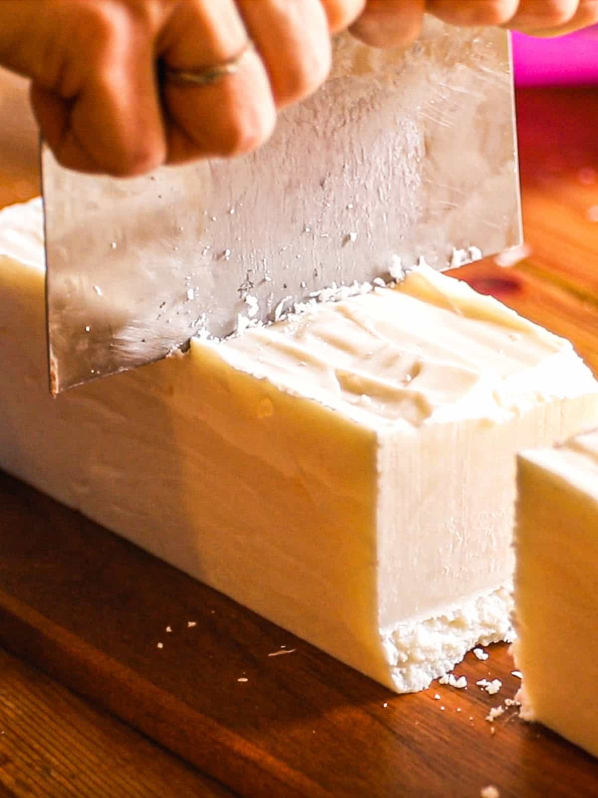 Cutting soap into large chunks with a cutter.