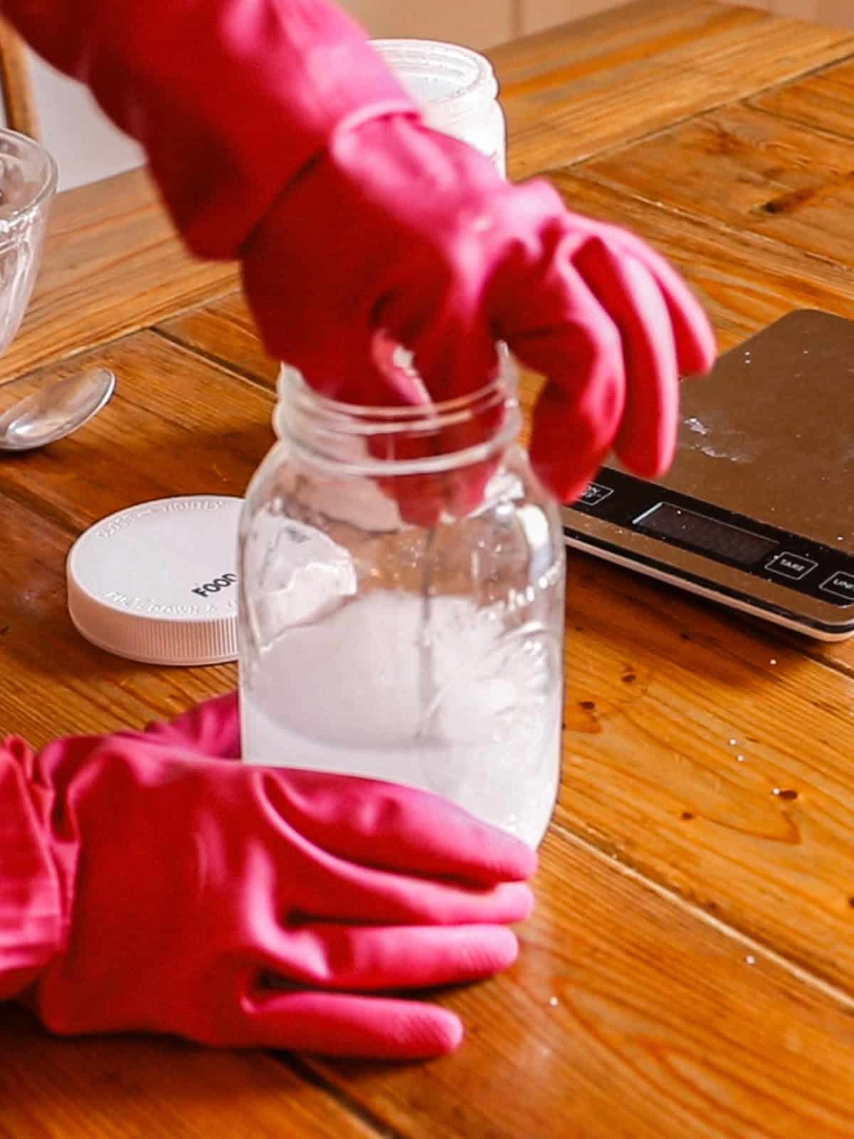 Stirring lye and water together with gloves on.