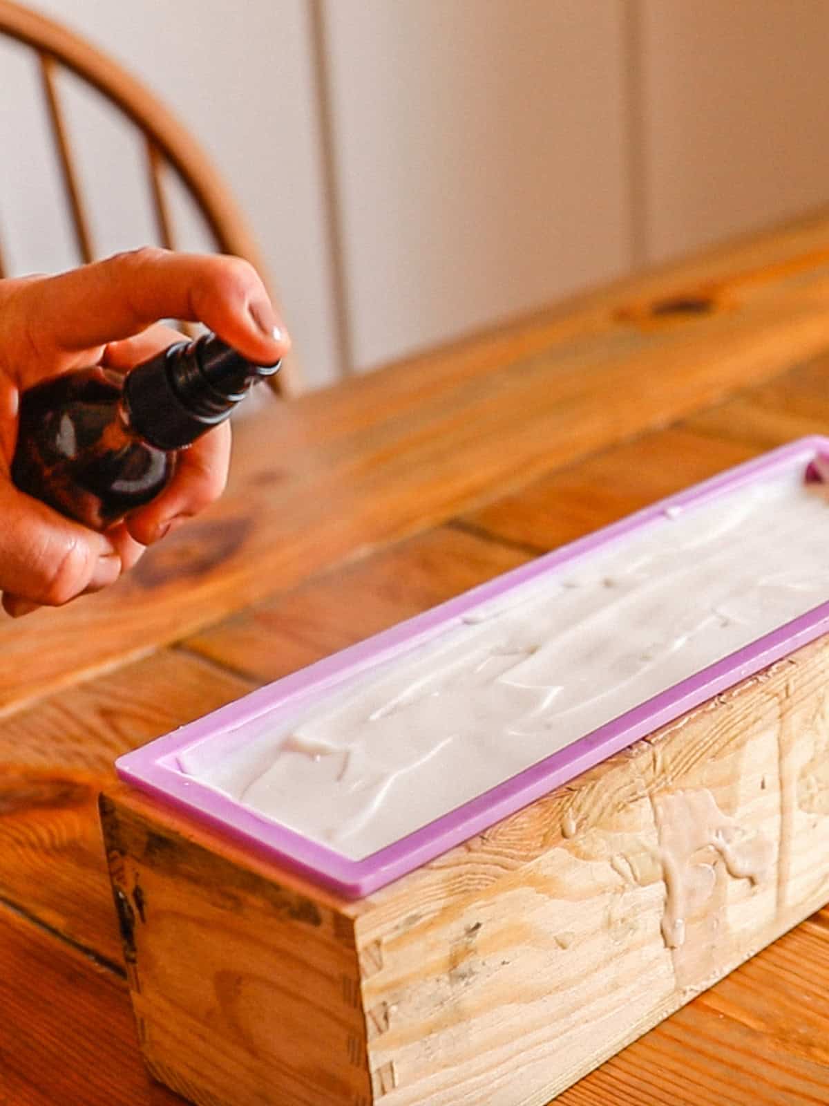 Spraying isopropyl alcohol onto the surface of the soap.
