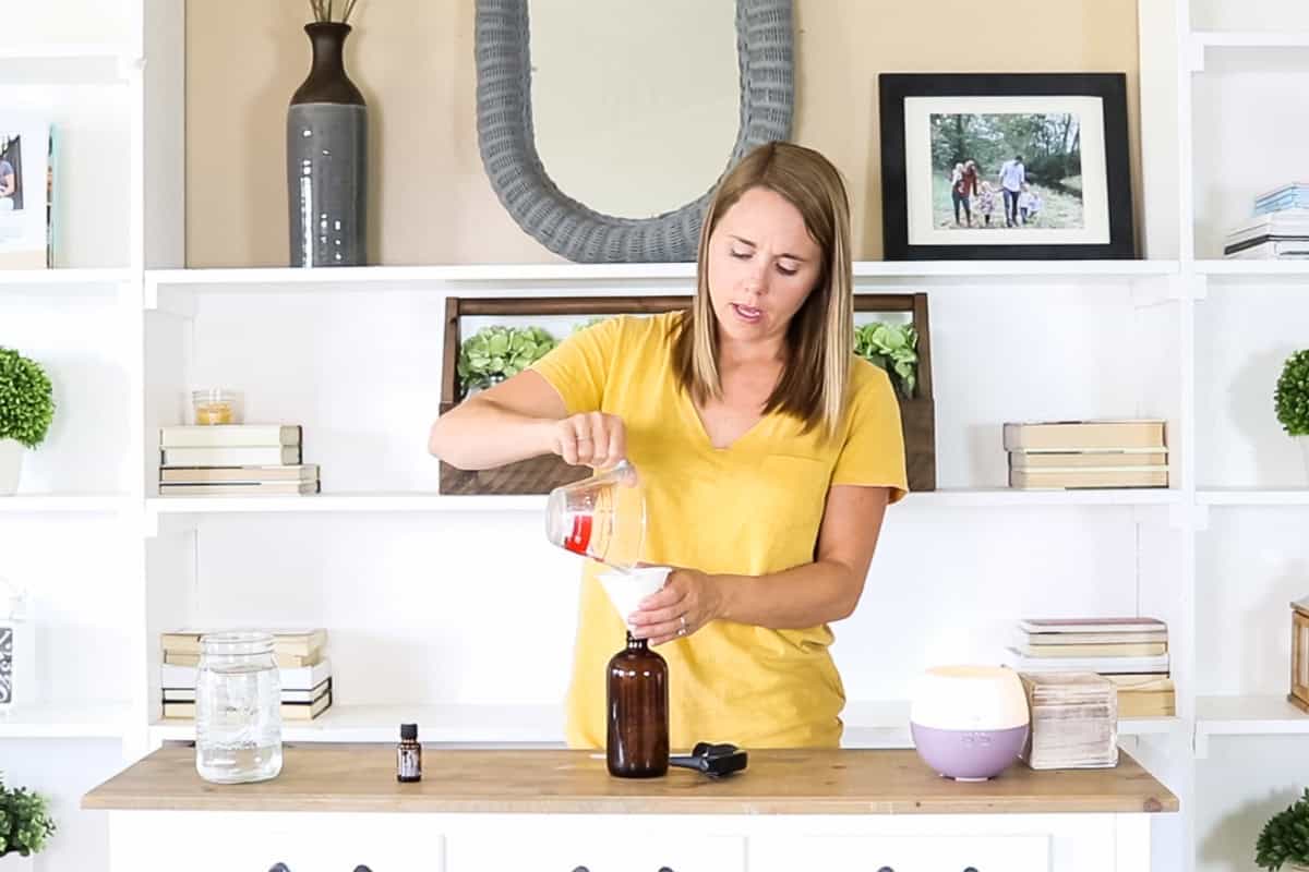 Pouring water into a spray bottle.