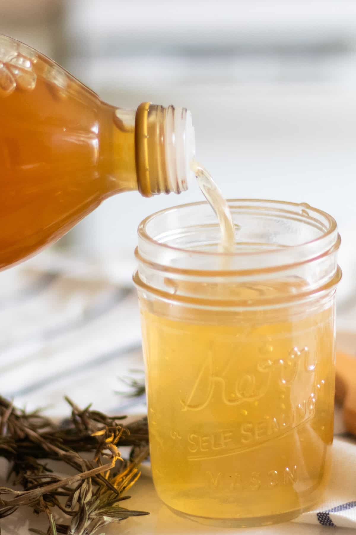 Pouring apple cider vinegar into a mason jar.