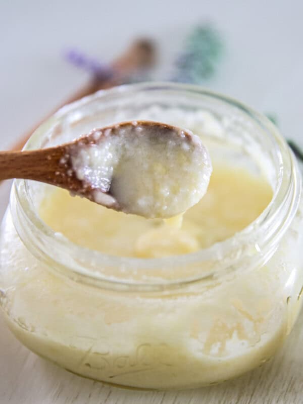 A spoonful of DIY face wash held over a jar of face wash.