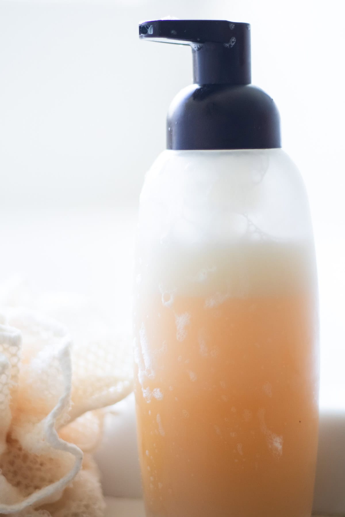 A foaming soap dispenser with face wash in it.
