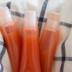 Three tubes of DIY lip gloss on a white and blue towel.