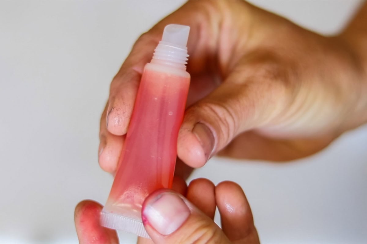 Holding a tube of DIY lip gloss.
