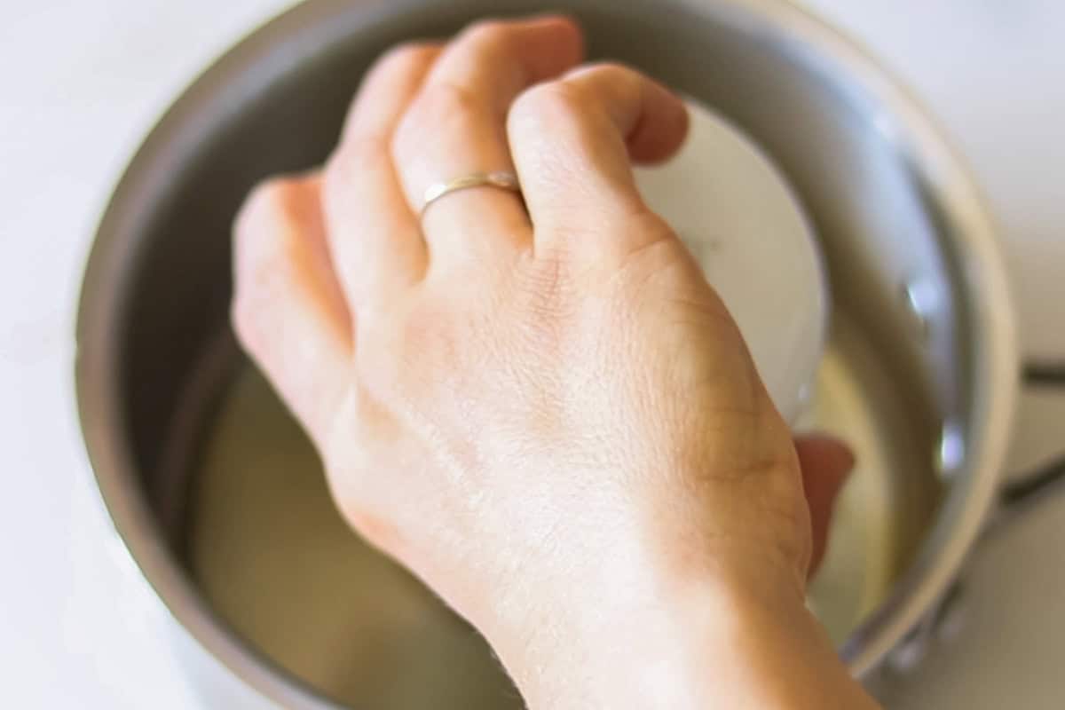 Pouring oil into a saucepan.