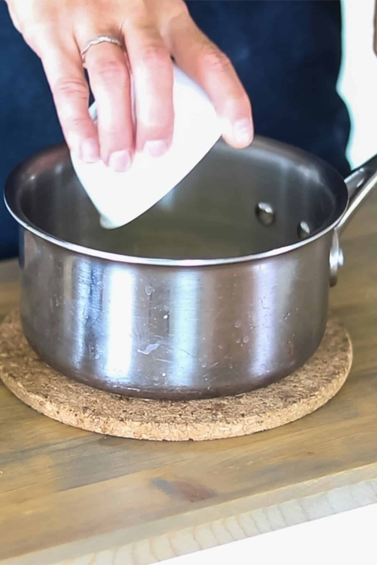 Pouring the ingredients for the itch cream into a small saucepan. 