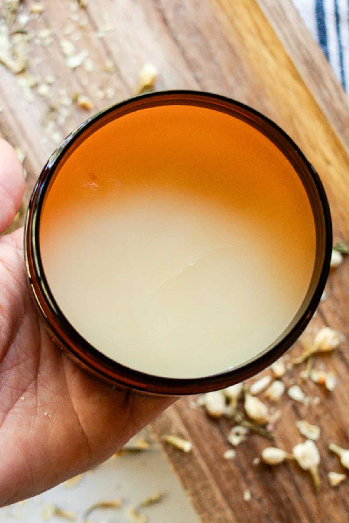 Holding up a jar or homemade tallow balm.