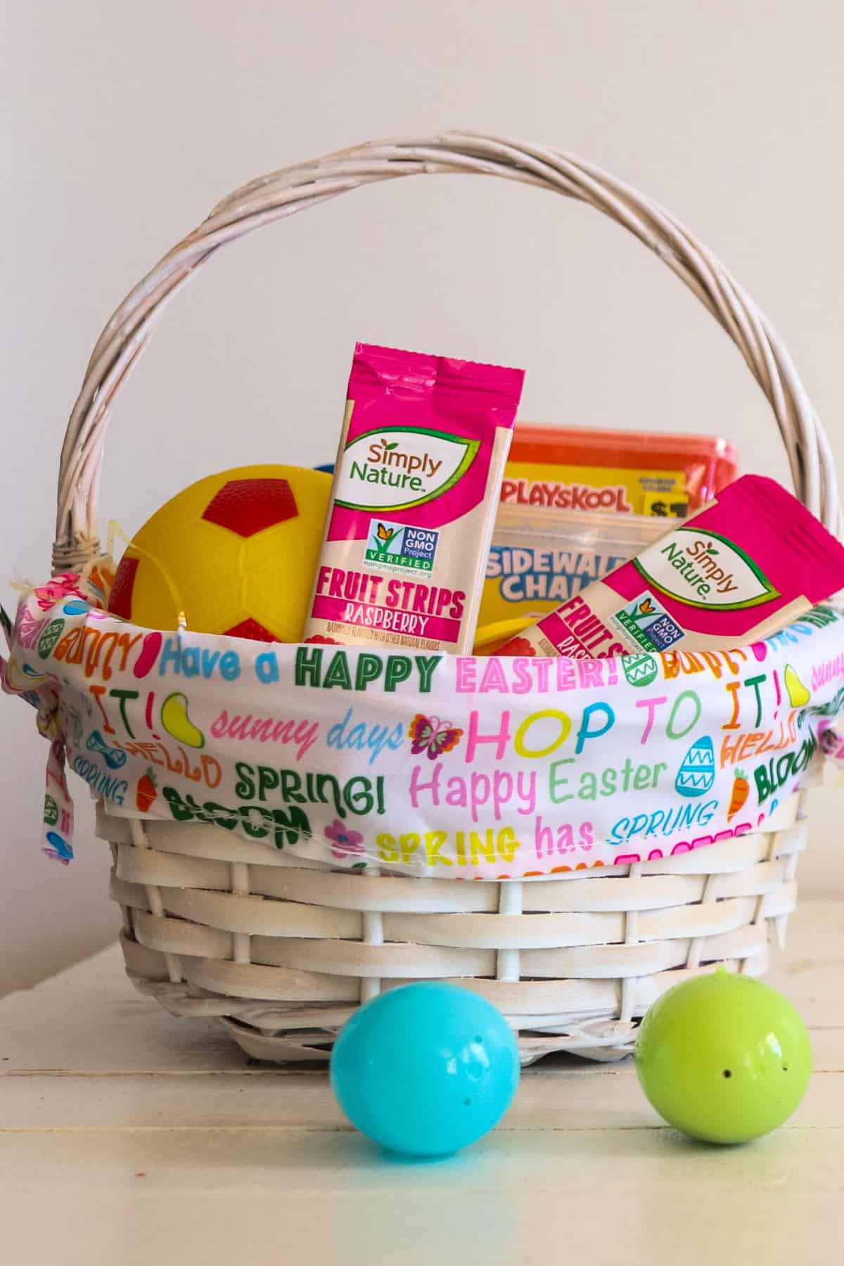 An Easter basket filled with non-candy treats and two plastic Easter eggs.