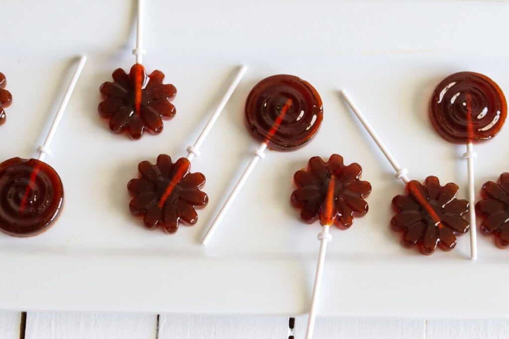 Healthy homemade lollipops laid out on a white table.