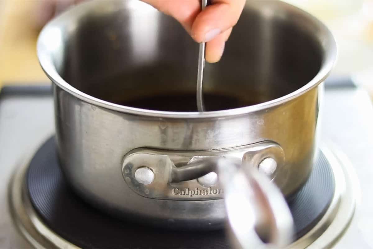 Stirring candy ingredients in a small saucepan.