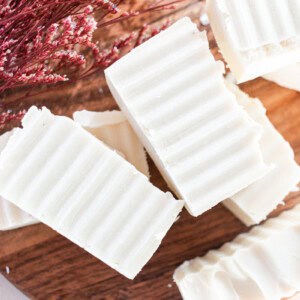 Shea butter soap bars curing on a wooden block.