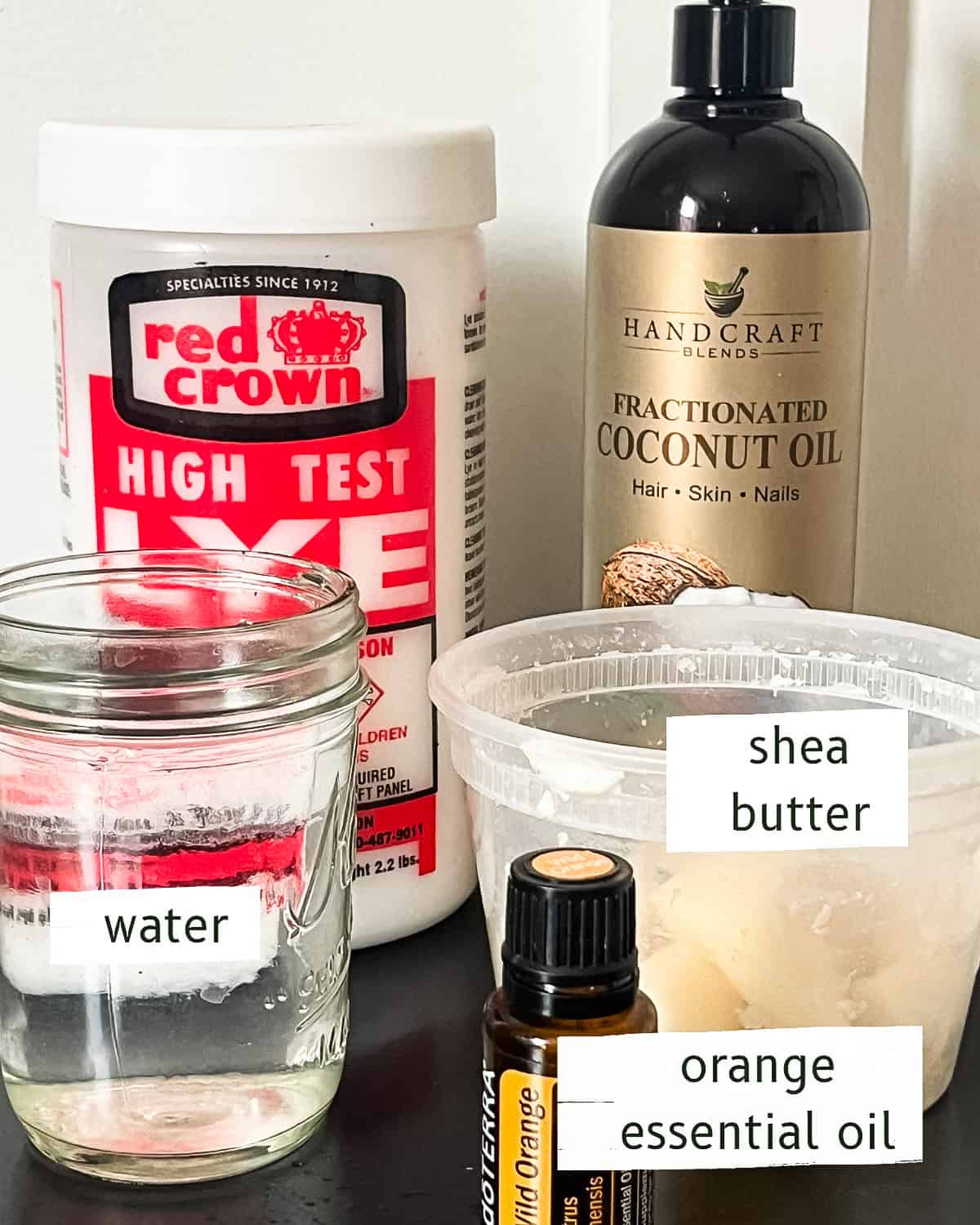 Ingredients to make shea butter soap laid out on a wooden table. 
