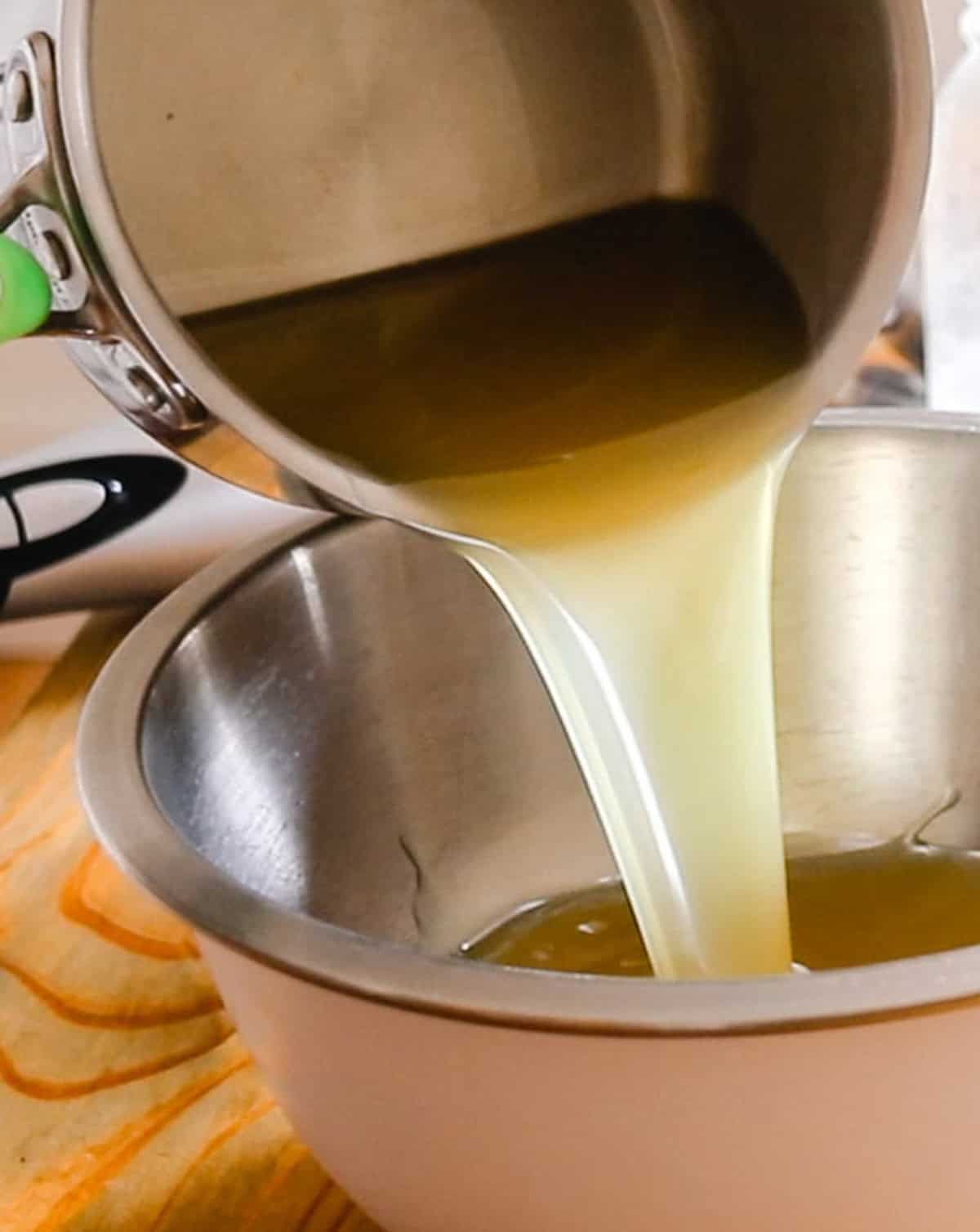 Pouring the melted fats into a mixing bowl to cool.