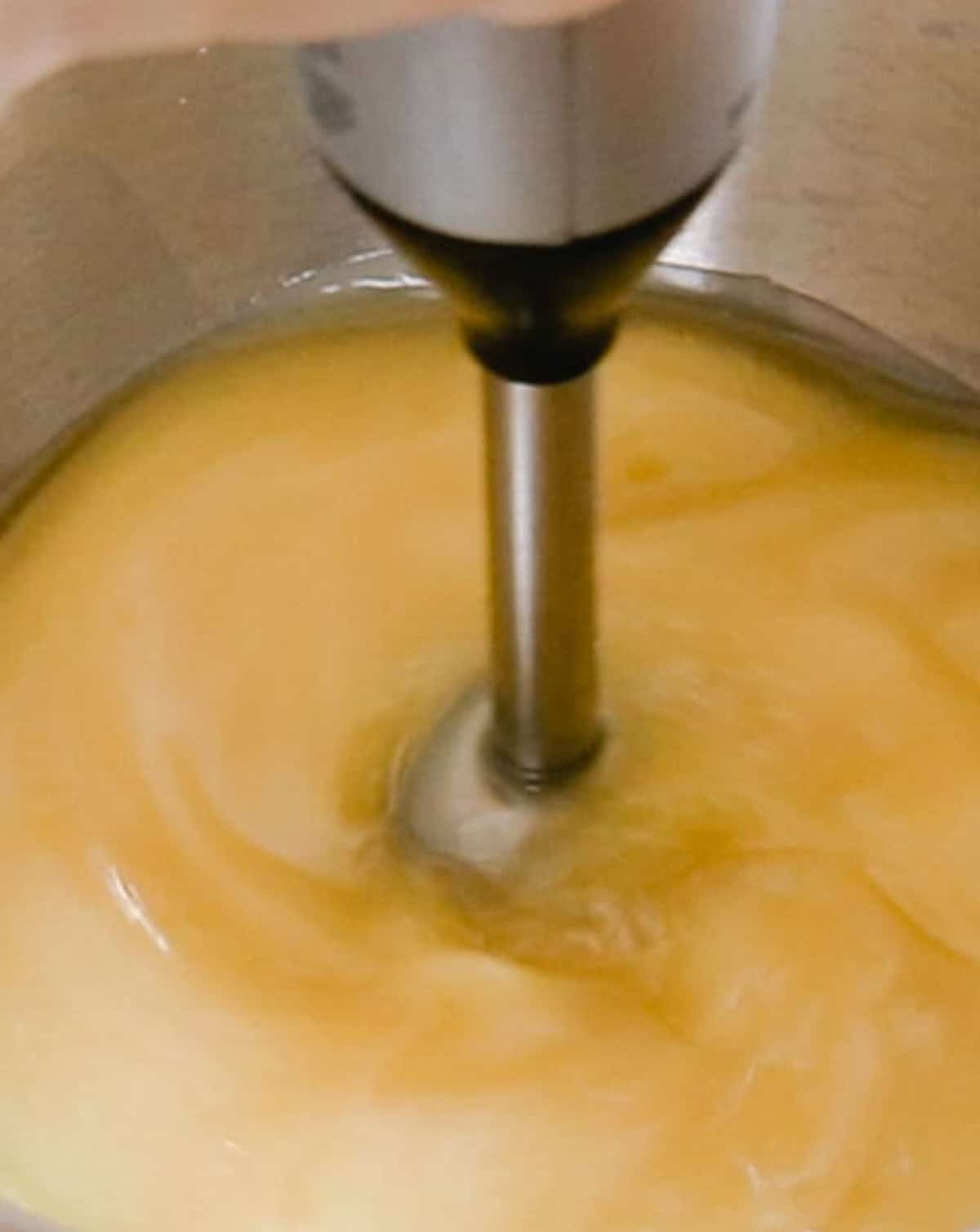 Using a immersion blender to bring the cold process soap to trace.