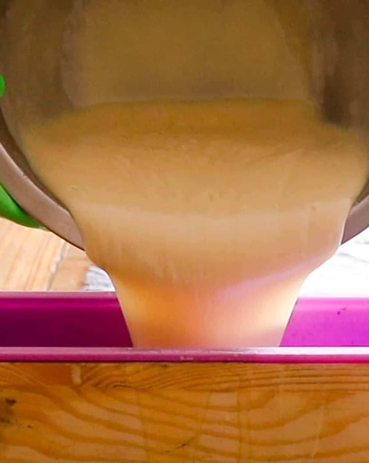 Pouring the melted cold process shea butter soap into a soap mold to cure.