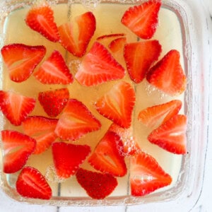 A baking dish of sugar free jello with sliced strawberries.