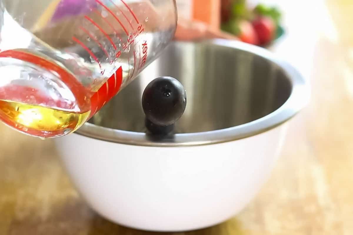 Pouring hot water into a metal mixing bowl.
