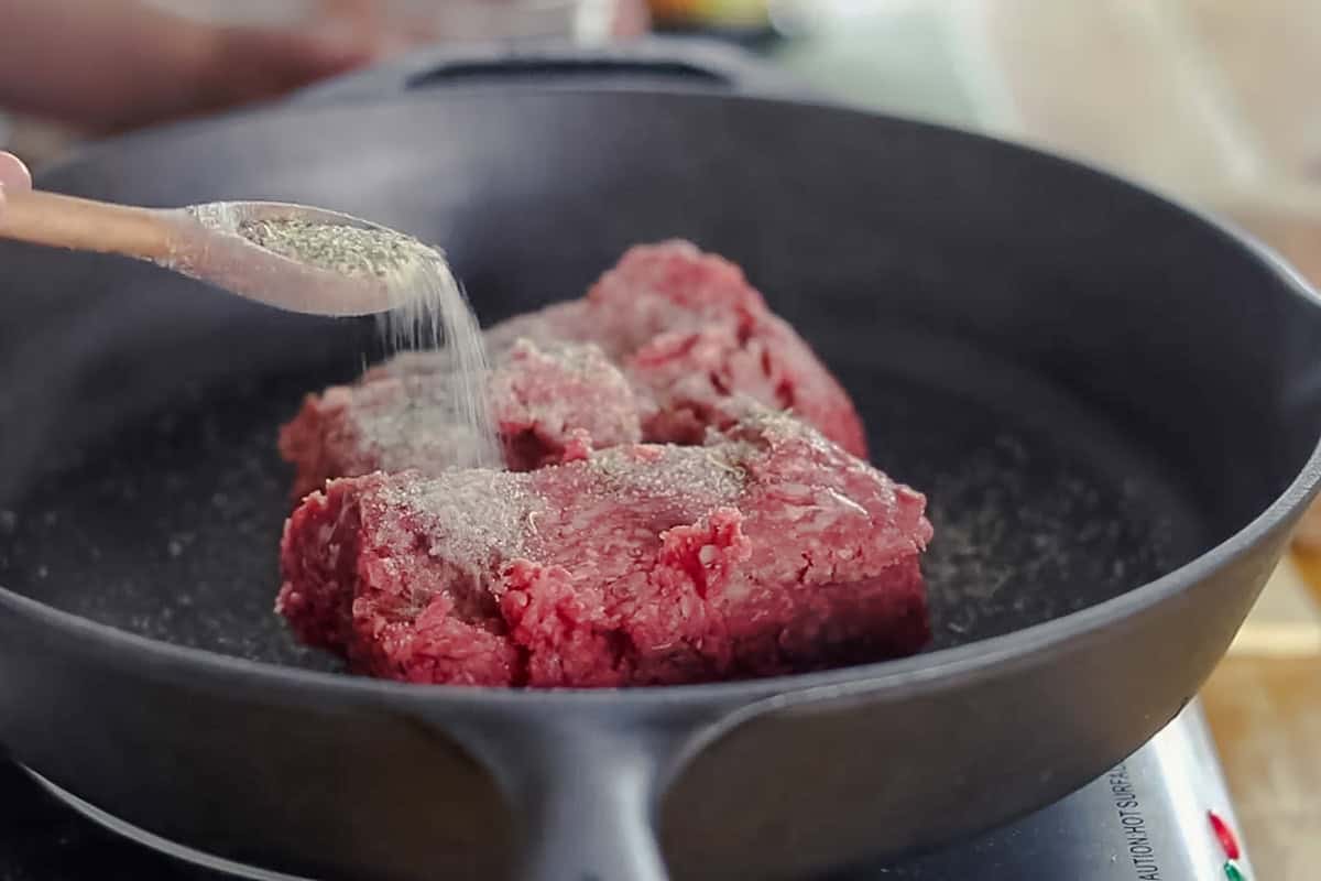 Browning breakfast sausage in a cast iron skillet.