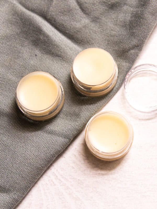 Circular containers of tallow lip balm assembled on a table.