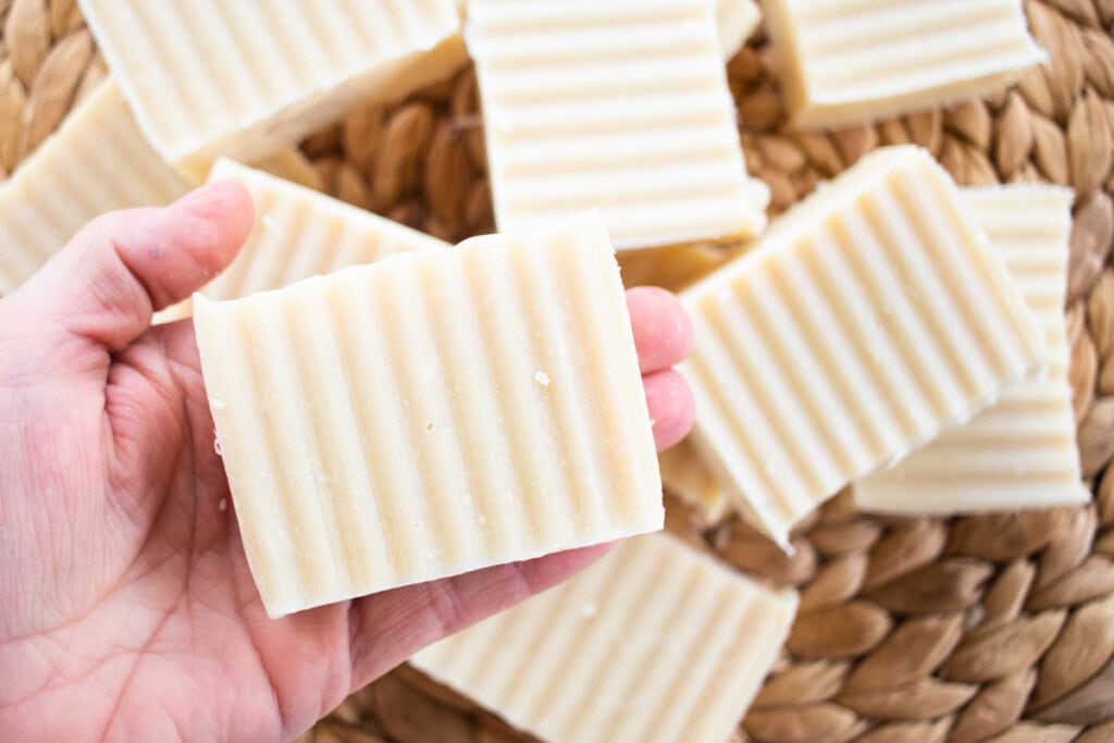 Holding a bar of beeswax soap. 