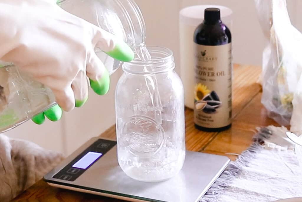 Pouring water into a jar set on a digital scale.
