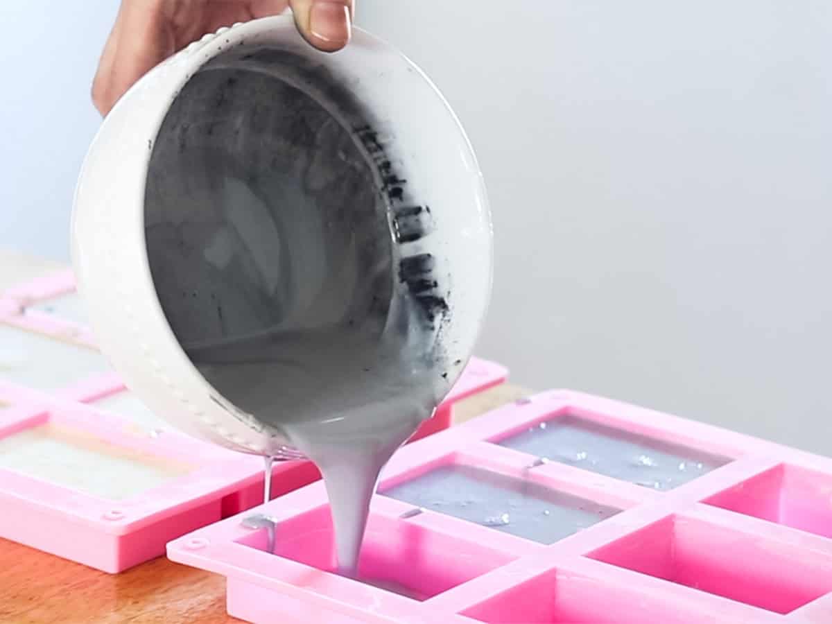 Pouring melted soap base into silicone soap molds.