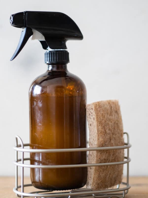 Homemade granite cleaner in a wire basket with a sponge.