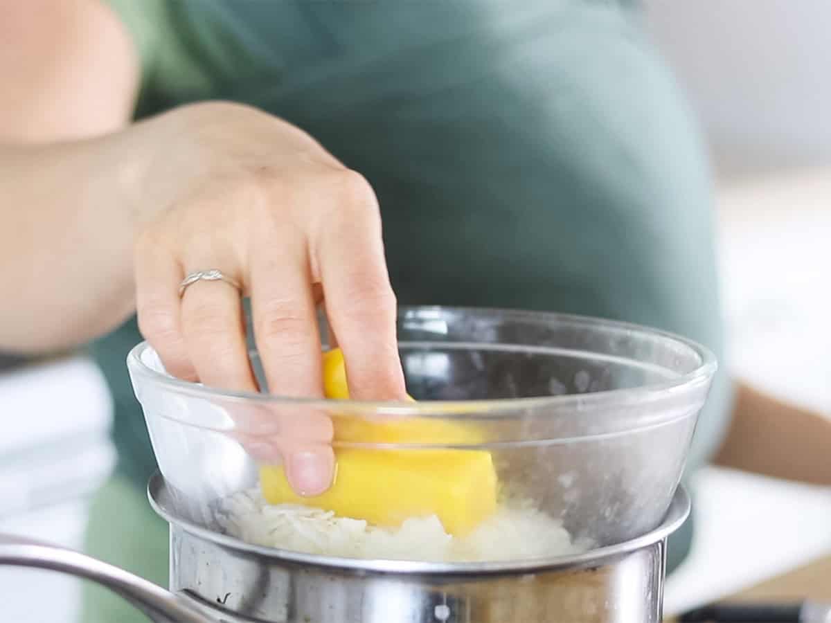 Adding beeswax to a double boiler.